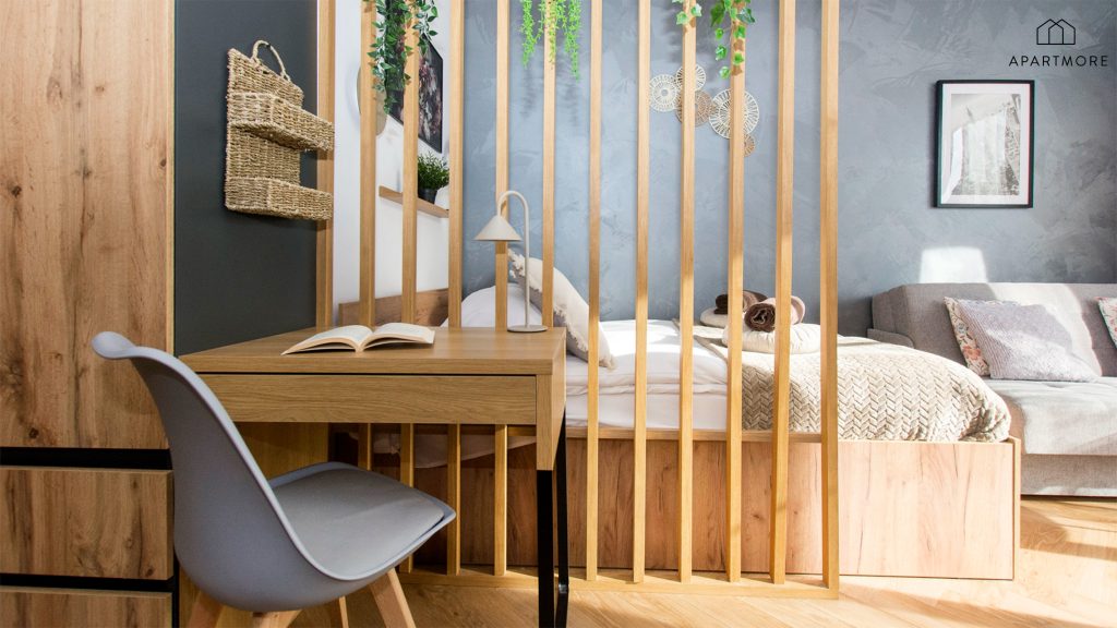 Escritorio de trabajo y dormitorio separado por una pared calada de madera