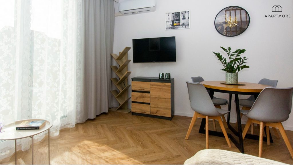 Zona de día con televisión, mesa para cuatro personas y aire acondicionado