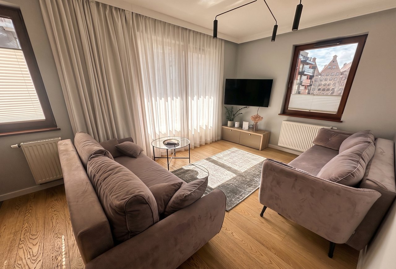 Living room of an apartment on Granary Island in Gdańsk with a view of the granaries, run by a short-term rental operator